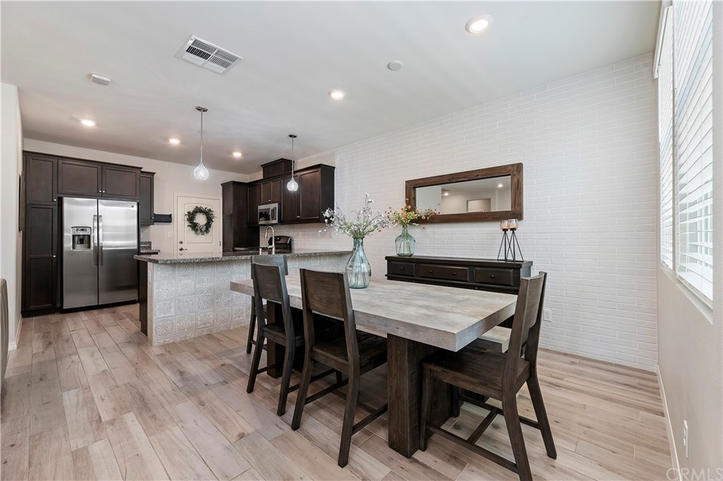 14557 Sienna Place Eastvale, CA 92880 - Photo 11 of 35 a view of a dining room with furniture window and wooden floor