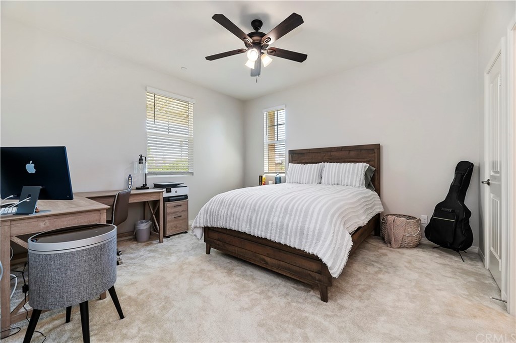 14557 Sienna Place Eastvale, CA 92880 - Photo 20 of 35 a bedroom with a bed and a desk