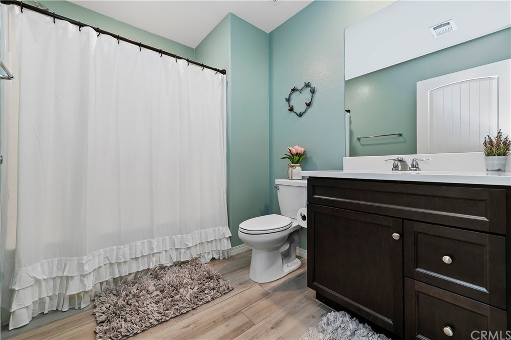 14557 Sienna Place Eastvale, CA 92880 - Photo 21 of 35 a bathroom with a toilet a sink and a mirror