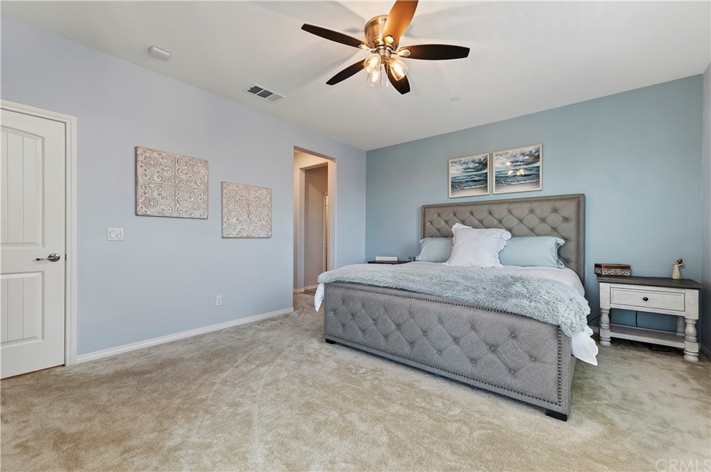 14557 Sienna Place Eastvale, CA 92880 - Photo 24 of 35 a bedroom with a bed and a painting on the wall