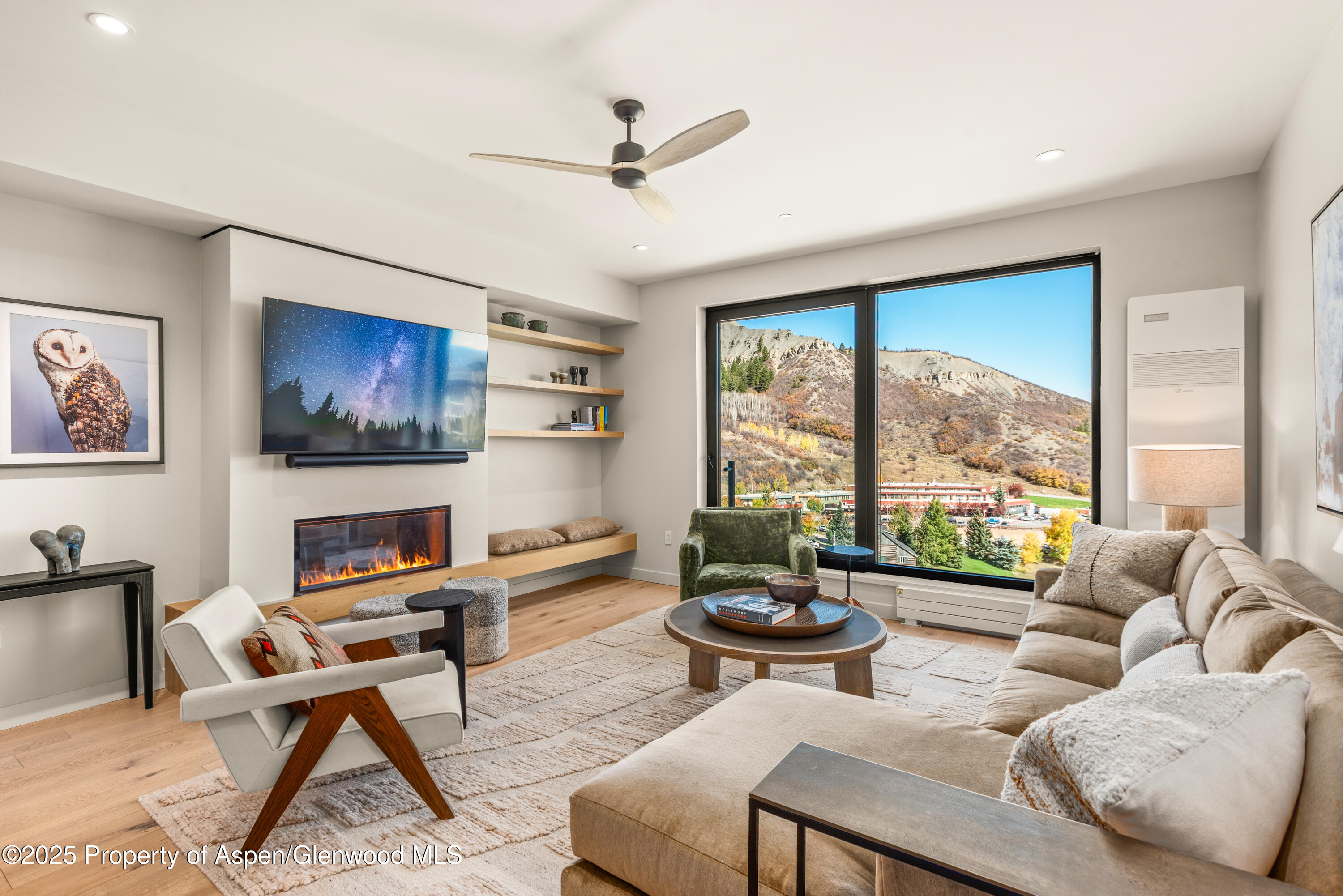 a living room with furniture a floor to ceiling windows and a flat screen tv