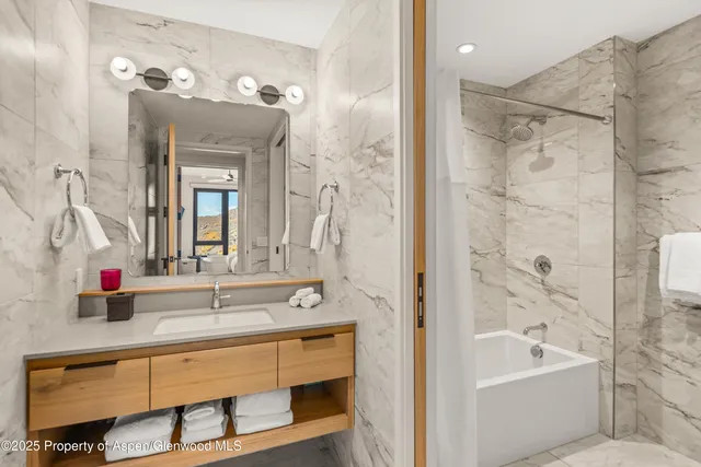 a bathroom with a tub sink and mirror