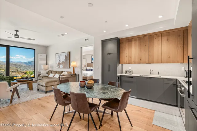 a kitchen with a dining table chairs and white cabinets