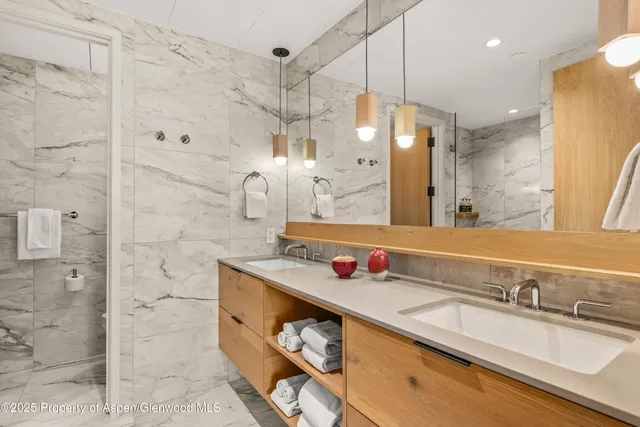 a bathroom with a granite countertop sink a mirror and shower