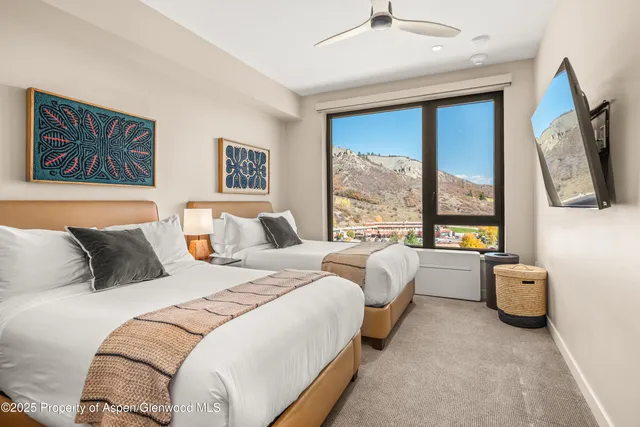 a spacious bedroom with two beds and a large window