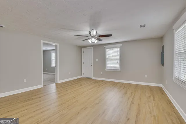 a view of a livingroom with a ceiling fan wooden floor and a ceiling fan