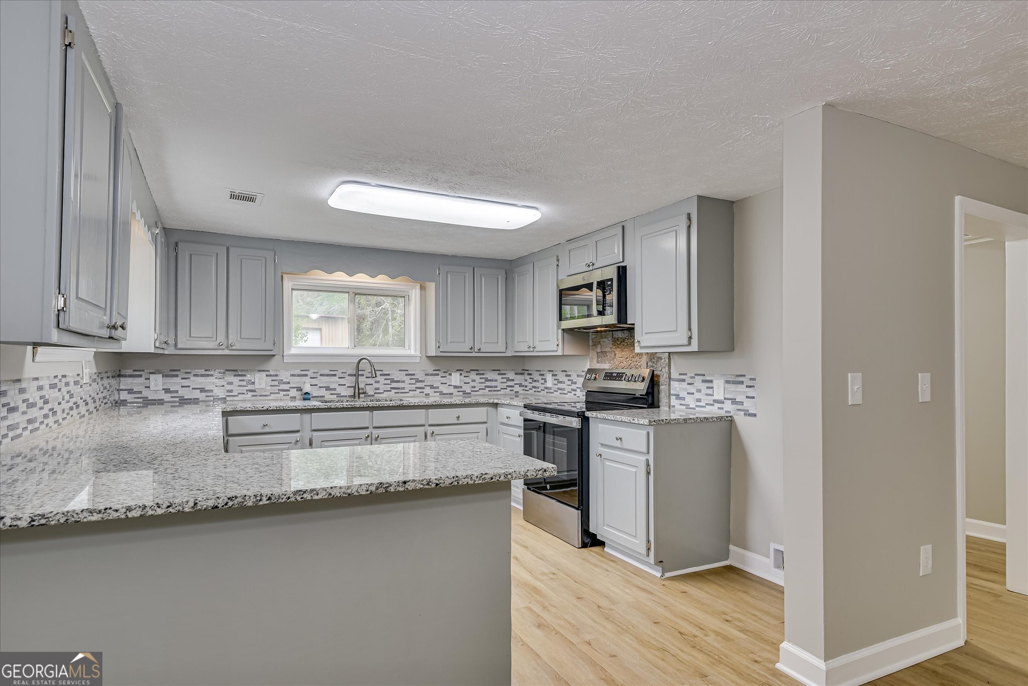 1321 Brett Road Wadley, GA 30477 - Photo 20 of 47 a kitchen with stainless steel appliances granite countertop a sink stove and refrigerator