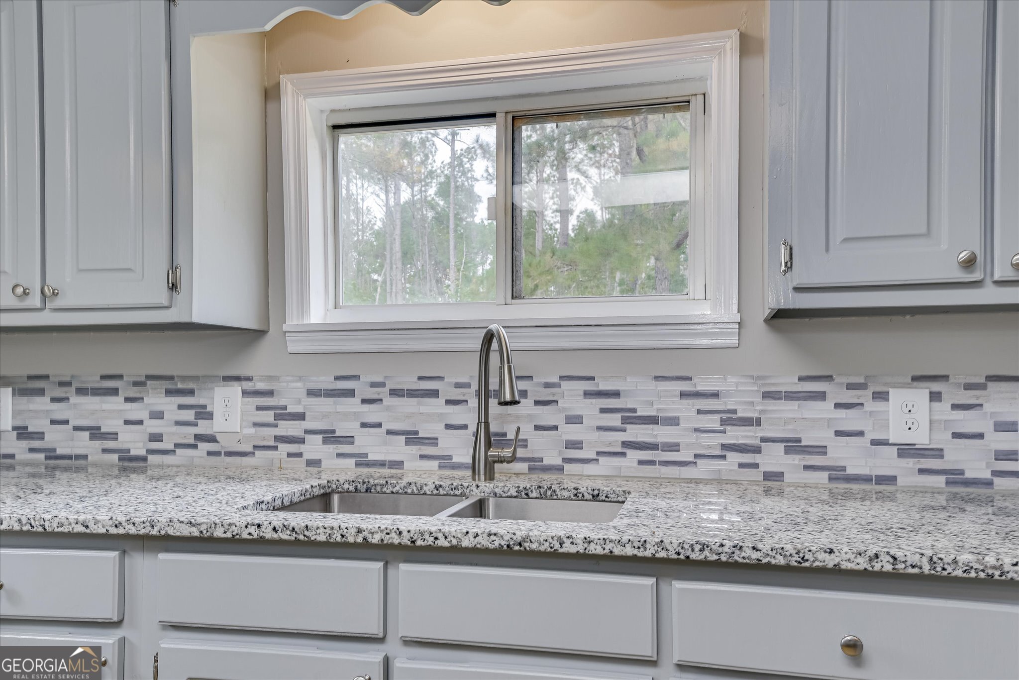 1321 Brett Road Wadley, GA 30477 - Photo 23 of 47 a kitchen with granite countertop white cabinets and a window