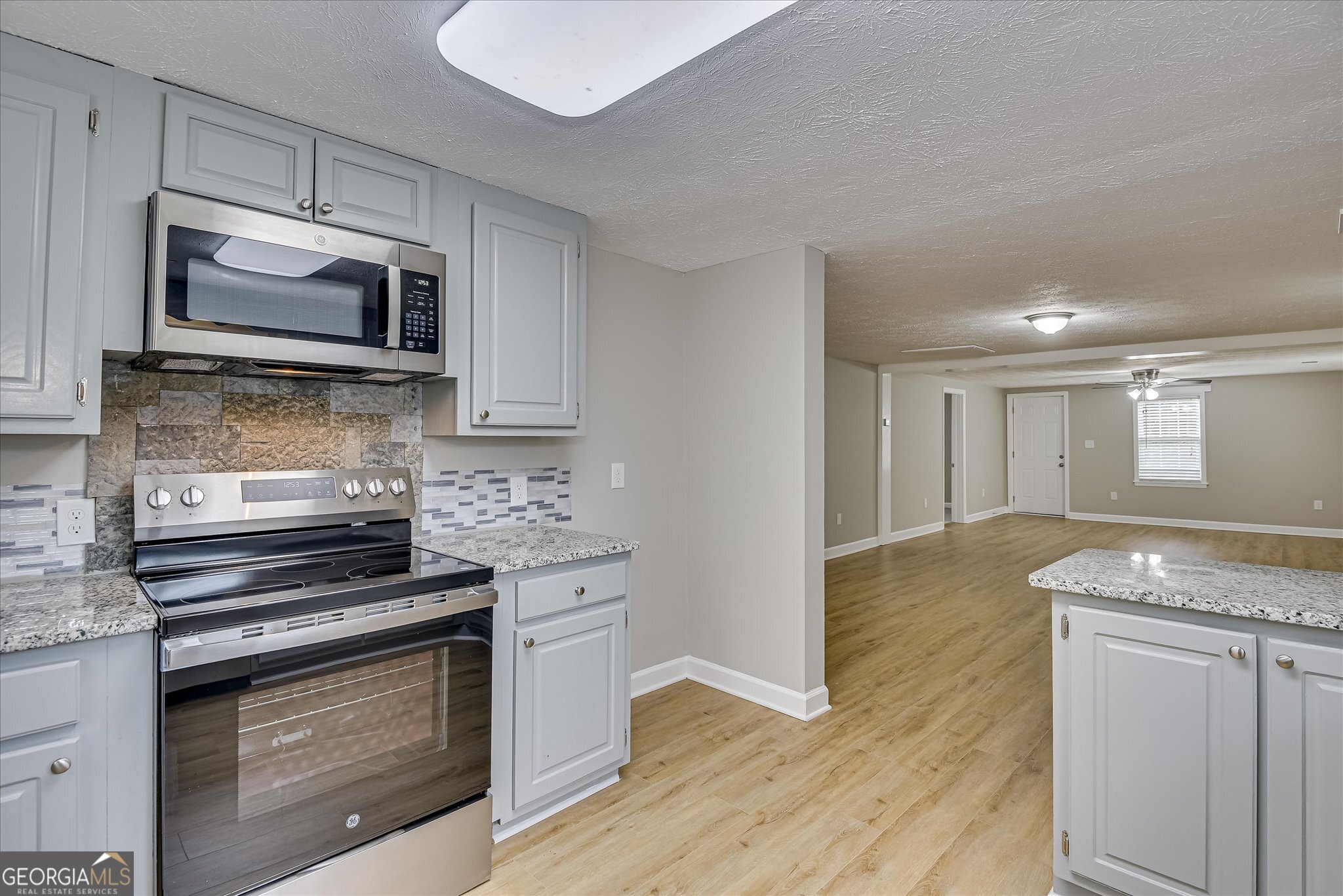 1321 Brett Road Wadley, GA 30477 - Photo 25 of 47 a kitchen with granite countertop a stove and a microwave