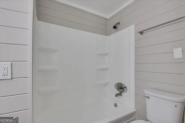 an empty room with ceiling fan and window