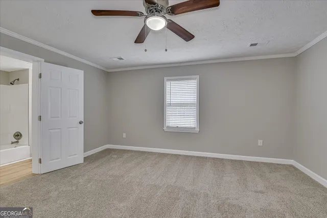 a view of an empty room with a ceiling fan