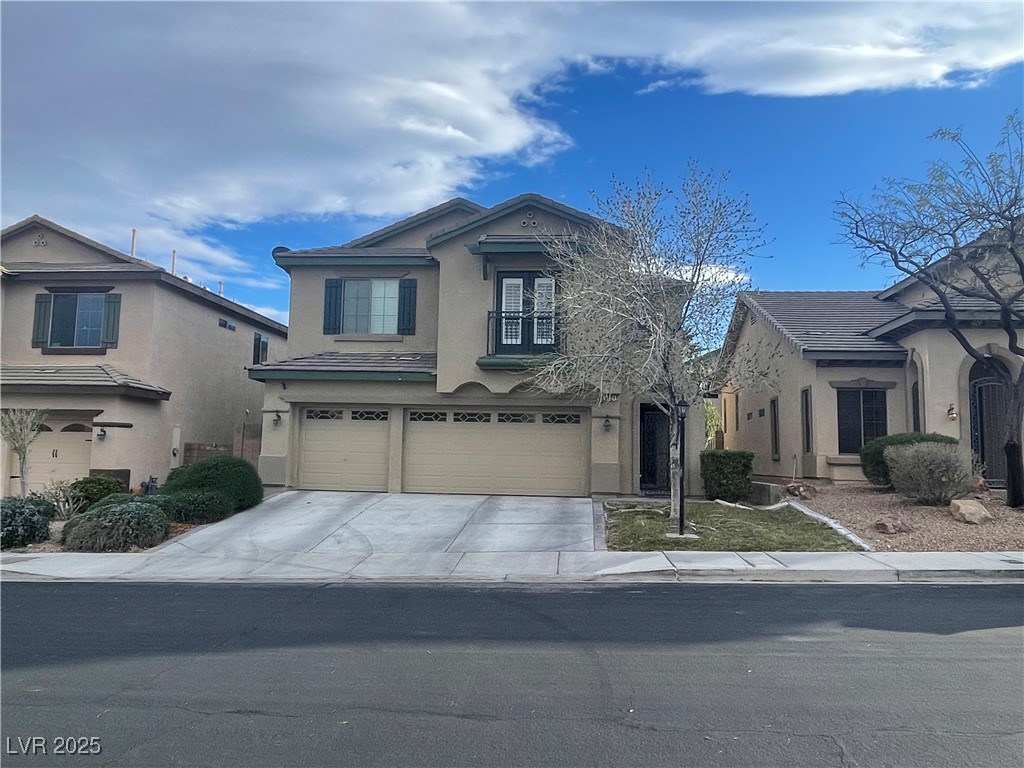 View of front of home with stucco siding, a garage, and driveway