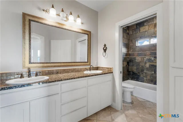 a bathroom with a toilet sink and mirror