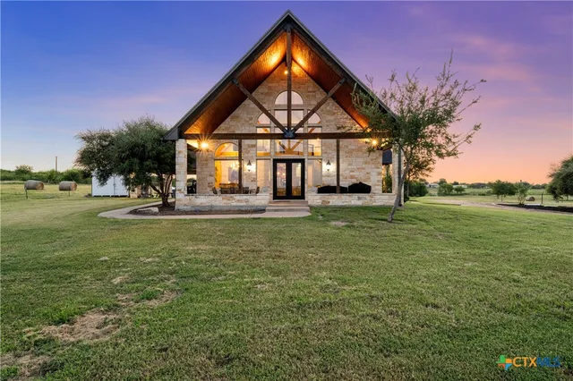 a front view of a house with garden and trees