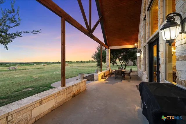 a view of a patio with table and chairs and floor to ceiling window