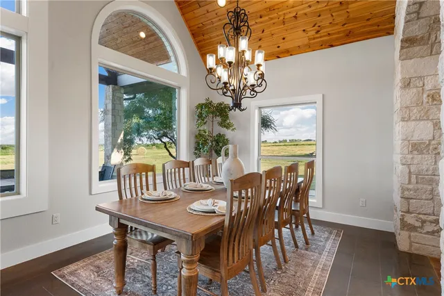 a view of a dining room with furniture a chandelier and wooden floor