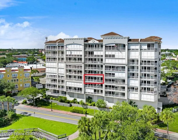 a front view of a building with a garden and plants