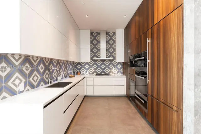 a kitchen with stainless steel appliances kitchen island granite countertop a refrigerator and a sink