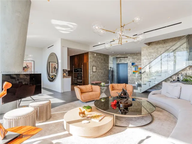 a living room with furniture chandelier and a view of kitchen