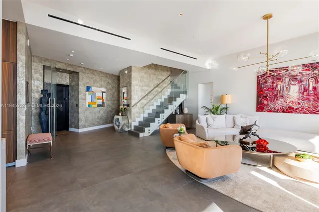 a living room with furniture and a chandelier