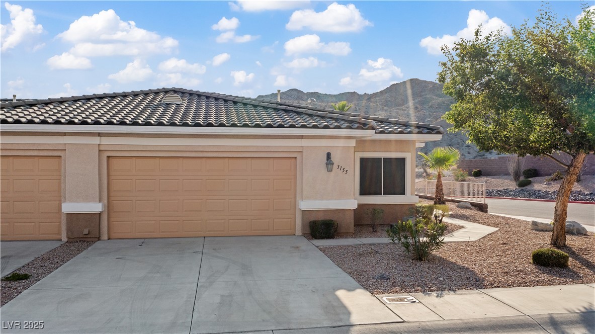 3155 Quail Song Drive Laughlin, NV 89029 - Photo 57 of 85 View of front of home featuring a mountain view, concrete driveway, stucco siding, an attached garage, and a tiled roof