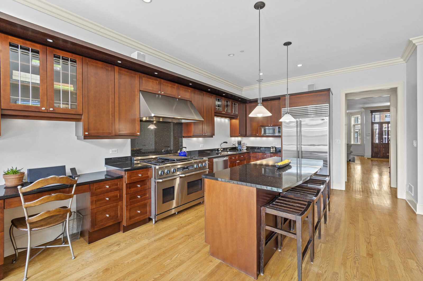 1423 West Lexington Street Chicago, IL 60607 - Photo 11 of 36 a kitchen with stainless steel appliances granite countertop a stove top oven a sink a dining table and chairs with wooden floor