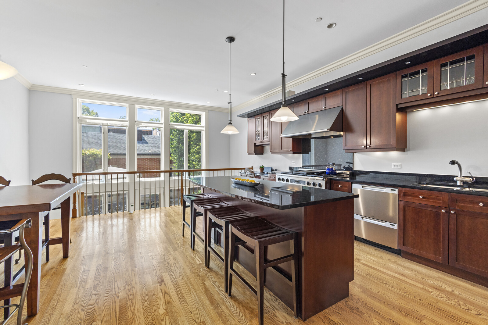 1423 West Lexington Street Chicago, IL 60607 - Photo 7 of 36 a kitchen with granite countertop a stove a sink a dining table and chairs