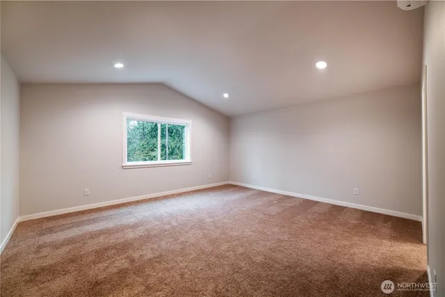 an empty room with windows and bathroom view