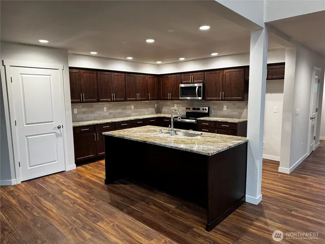a kitchen with stainless steel appliances granite countertop a sink stove and refrigerator