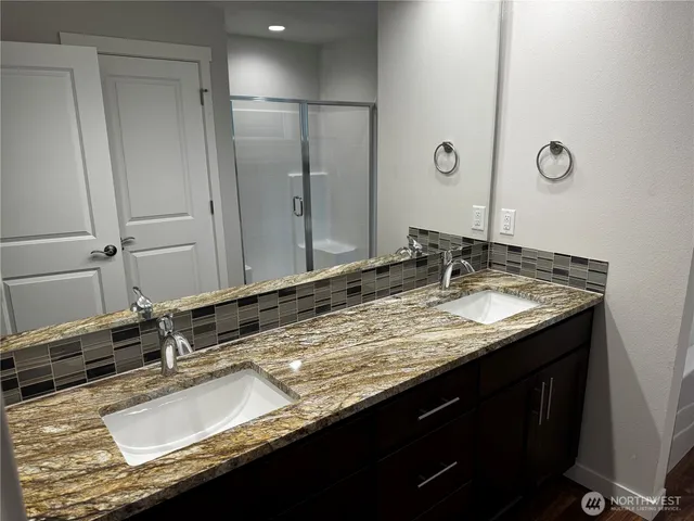 a bathroom with a granite countertop sink and a large mirror