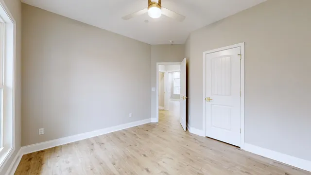 an empty room with wooden floor and window