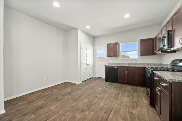 a kitchen with stainless steel appliances granite countertop a stove a sink and a refrigerator
