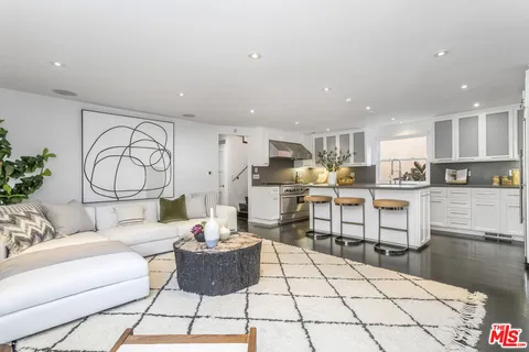 a view of a rooftop deck with couch and chairs