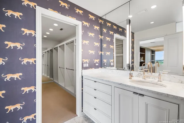 a bathroom with a granite countertop sink a mirror and a shower