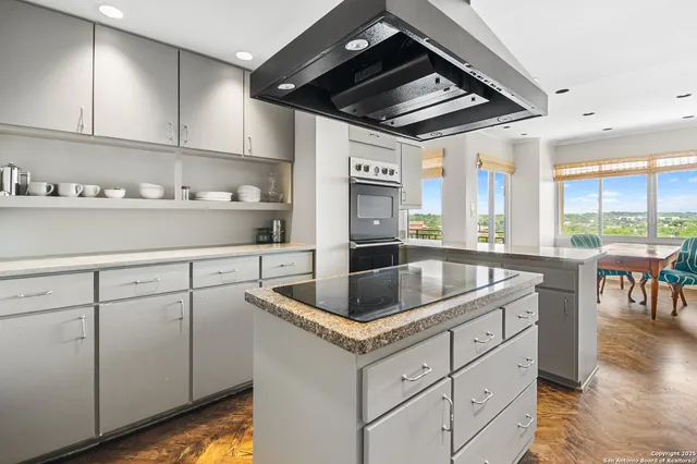 a kitchen with granite countertop a sink stainless steel appliances and cabinets