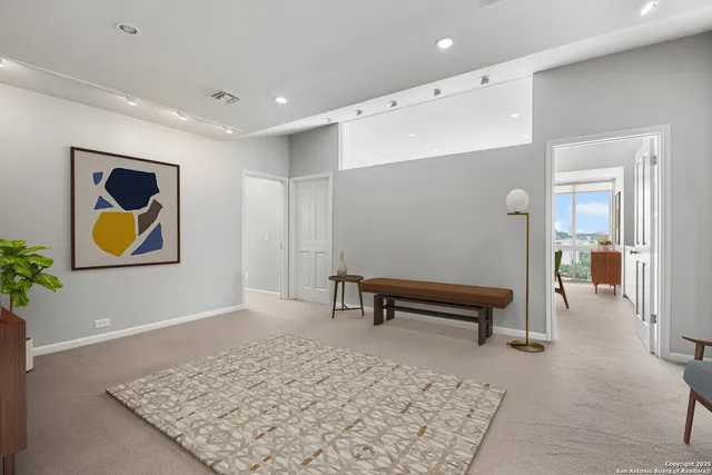 a hallway with painting and a rug