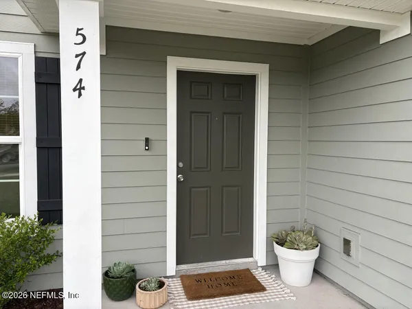 a view of a door of the house and a potted plant