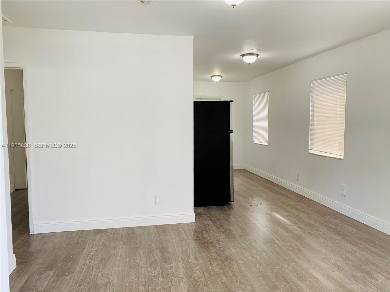 738 Northeast 86th Street, Unit 8 Miami, FL 33138 - Photo 3 of 9 a view of an empty room with wooden floor and a window