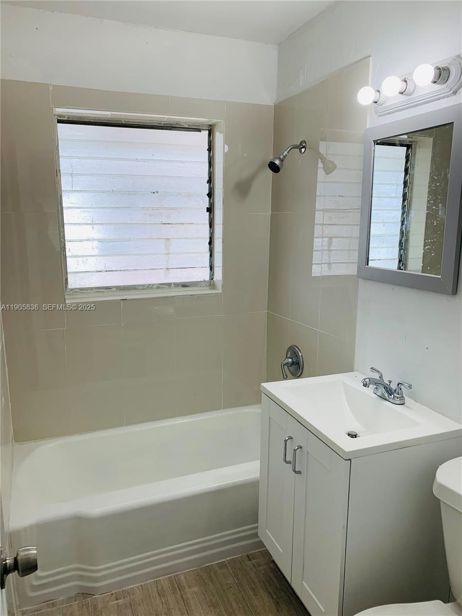 738 Northeast 86th Street, Unit 8 Miami, FL 33138 - Photo 5 of 9 a bathroom with a tub sink and mirror