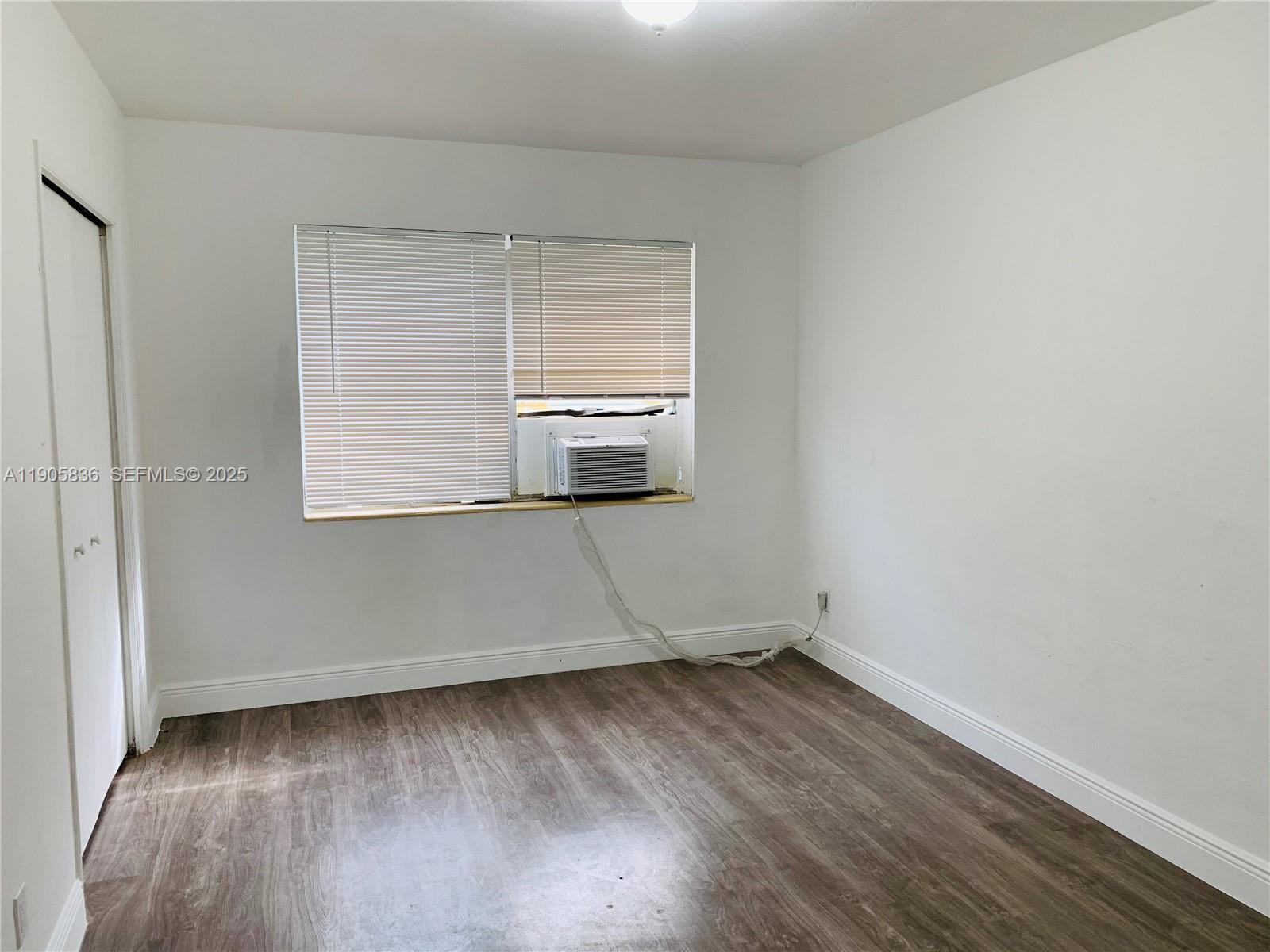 738 Northeast 86th Street, Unit 8 Miami, FL 33138 - Photo 8 of 9 a view of a room with wooden floor and white wall