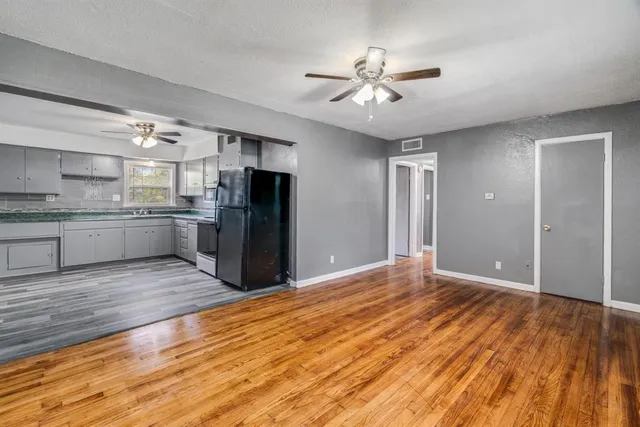 a view of a kitchen with a sink and wooden floor