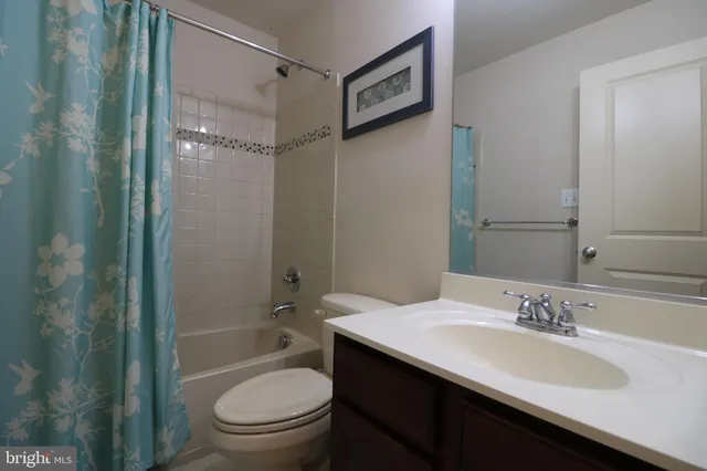 a bathroom with a granite countertop sink toilet a shower and a mirror