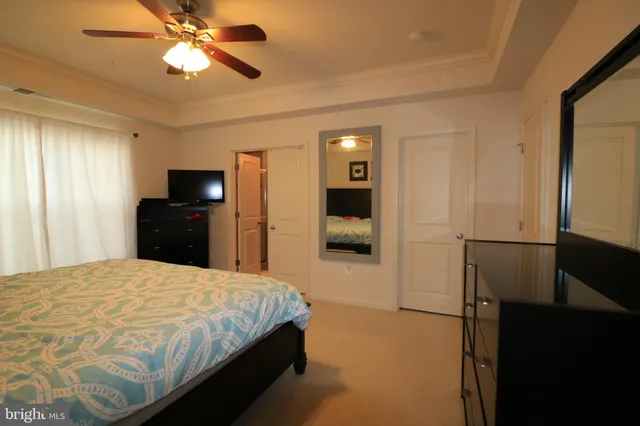 a bedroom with a bed and a flat tv screen on dresser