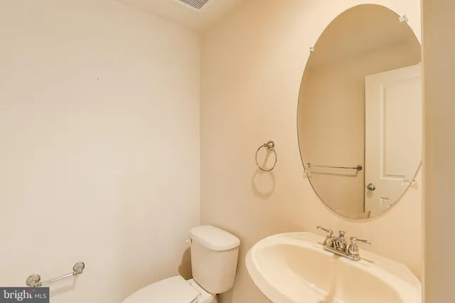a bathroom with a sink mirror and toilet