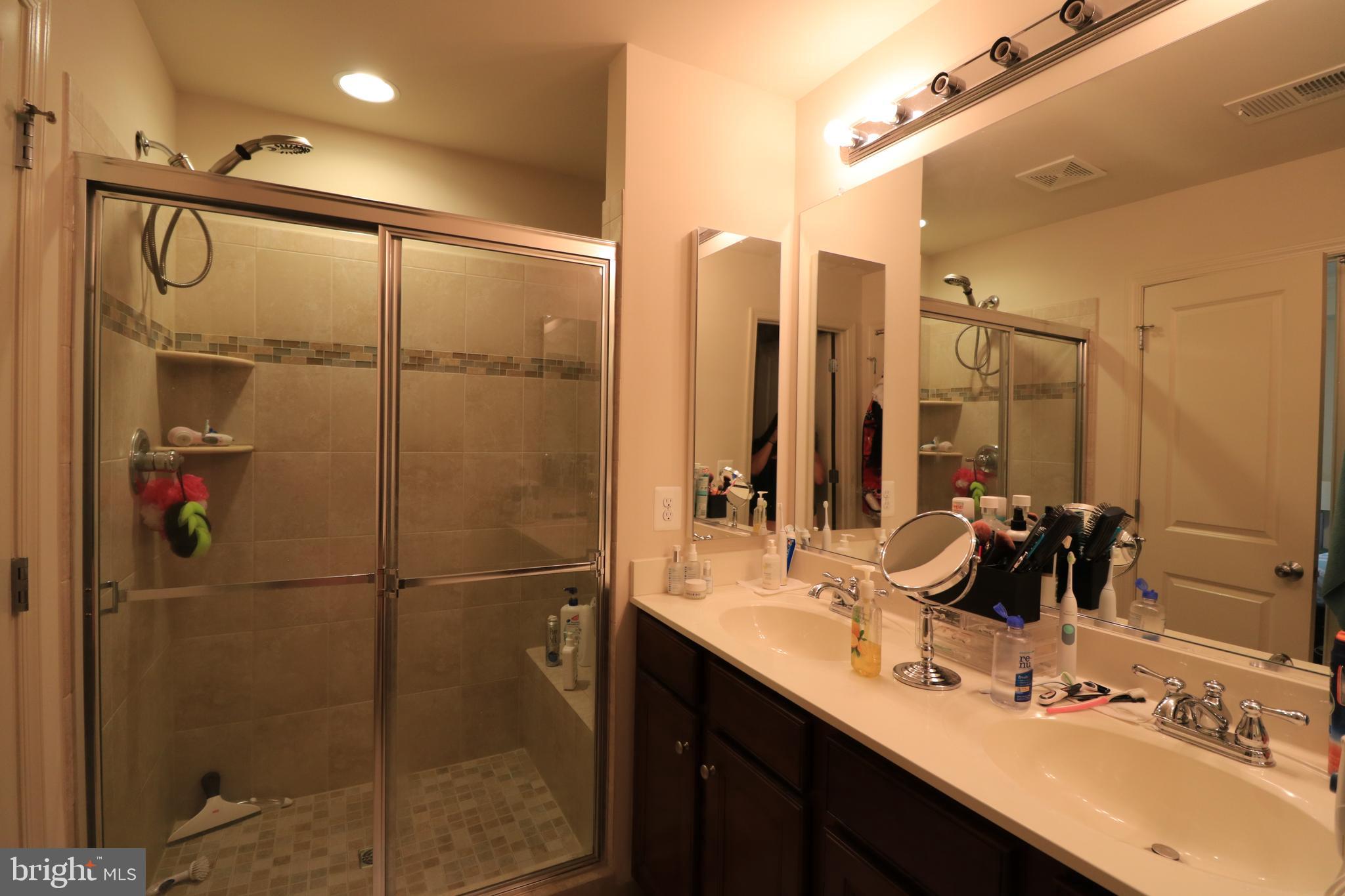 13411 Deer Highlands Way Silver Spring, MD 20906 - Photo 17 of 32 a bathroom with a double vanity sink a mirror and shower