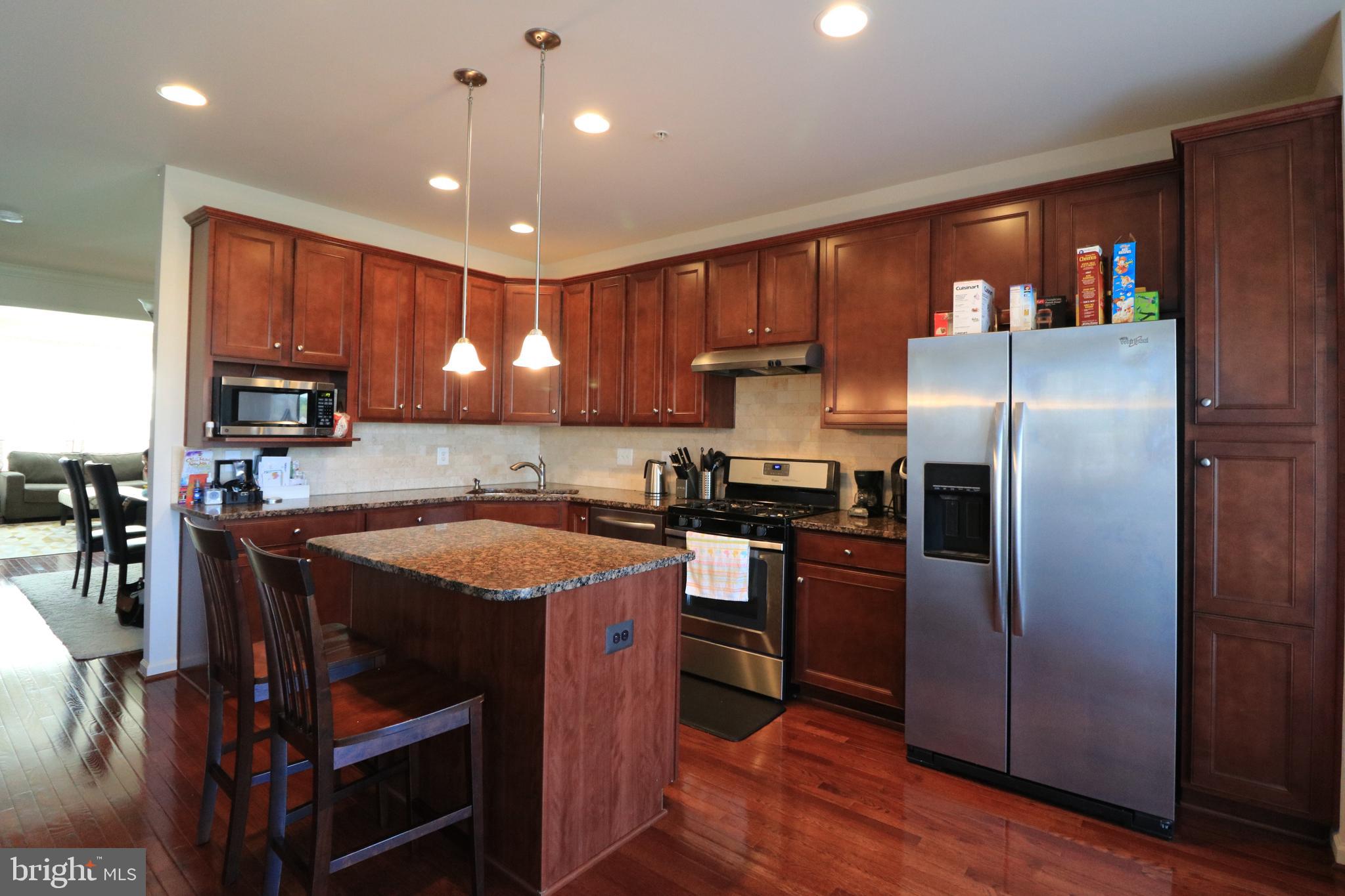 13411 Deer Highlands Way Silver Spring, MD 20906 - Photo 2 of 32 a kitchen with stainless steel appliances granite countertop a refrigerator a stove a sink a dining table and chairs