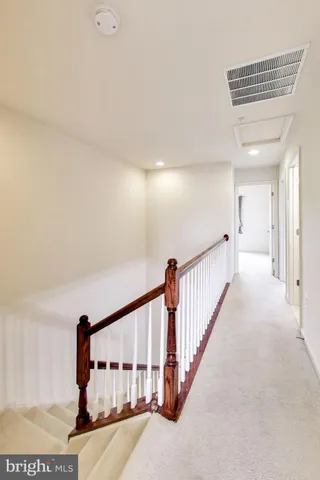 a view of staircase with lots of frames and a rug