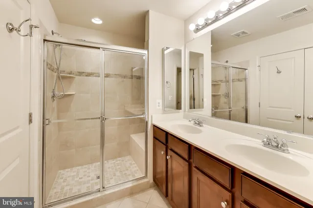 a bathroom with a double vanity sink mirror and shower