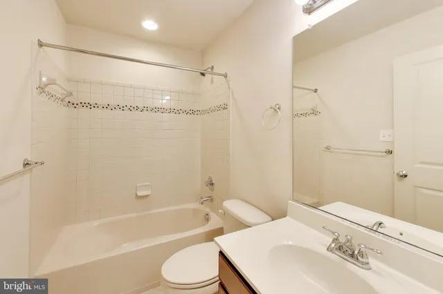 a bathroom with a bathtub shower sink vanity and toilet
