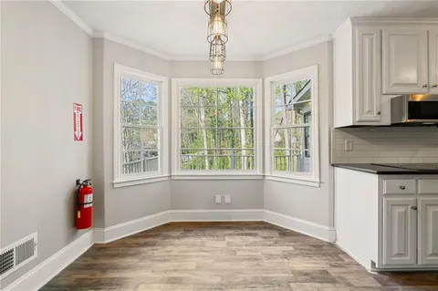 a kitchen with stainless steel appliances granite countertop a refrigerator a stove a sink and white cabinets
